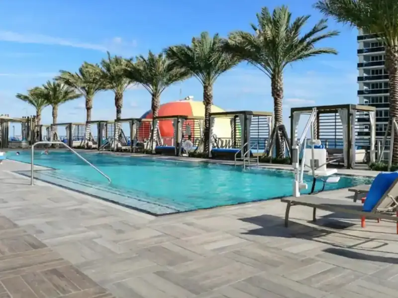 Resort pool with palm trees and cabanas